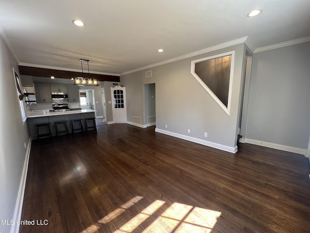 unfurnished living room featuring crown molding, visible vents, dark wood finished floors, and baseboards