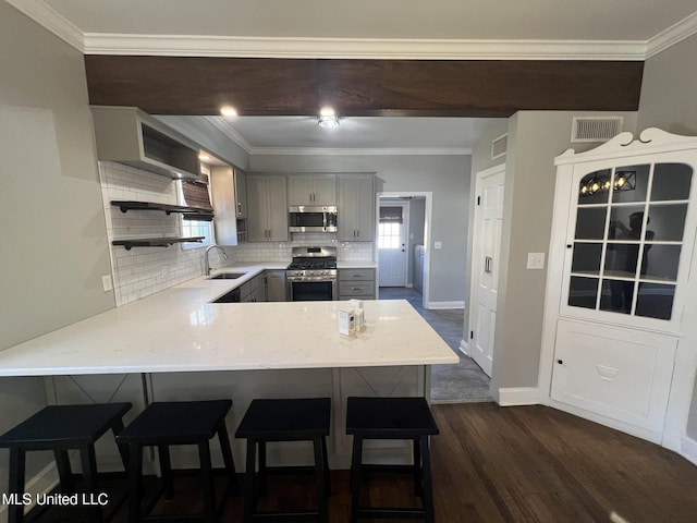 kitchen featuring a peninsula, stainless steel appliances, visible vents, light countertops, and gray cabinets