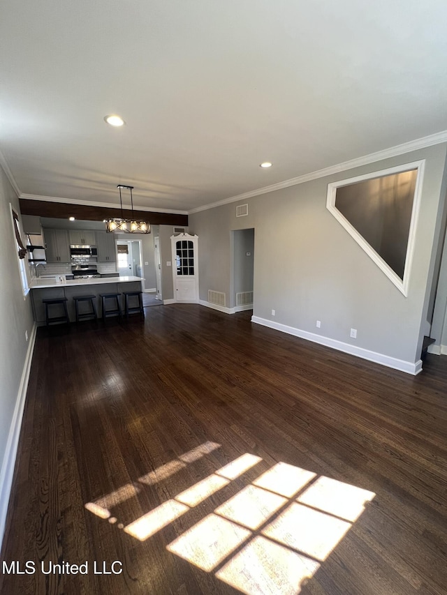 unfurnished living room with dark wood-style floors, crown molding, and baseboards