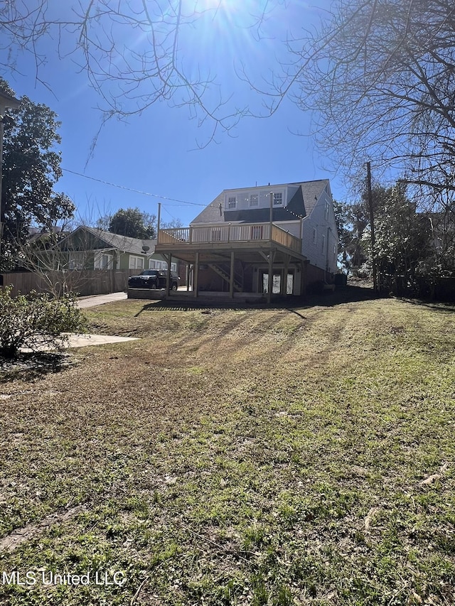 rear view of house featuring a deck and a yard