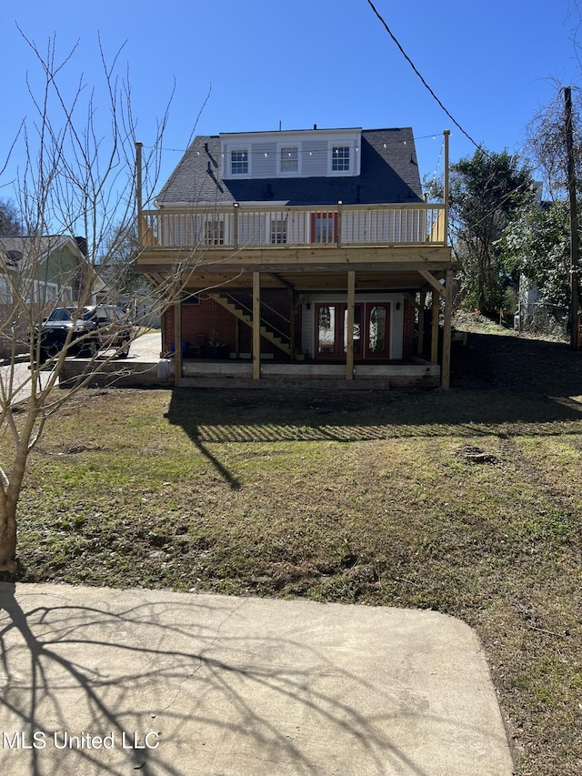 rear view of house featuring a yard, stairway, and a wooden deck