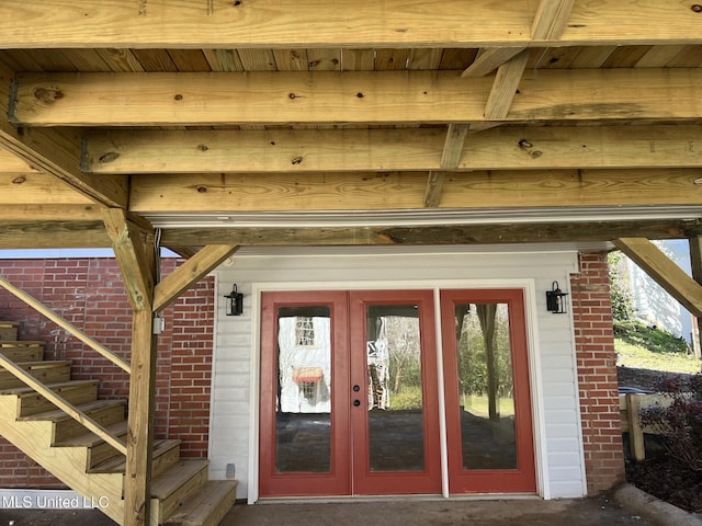 entrance to property featuring brick siding and french doors