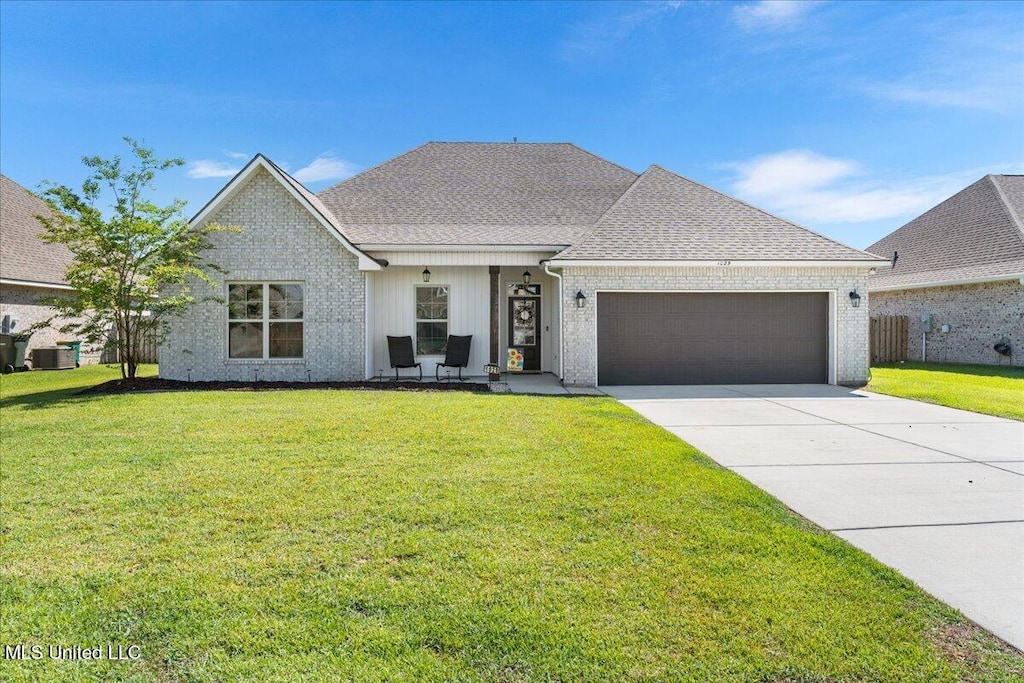 1029 Castine Pointe Blvd, Long Beach, MS 39560 - view of front of house featuring a garage, driveway, a front yard, and a shingled roof