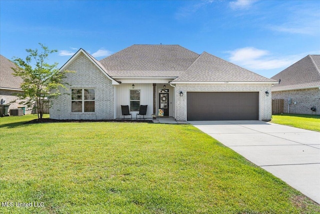 view of front of house featuring a garage, driveway, a front yard, and a shingled roof