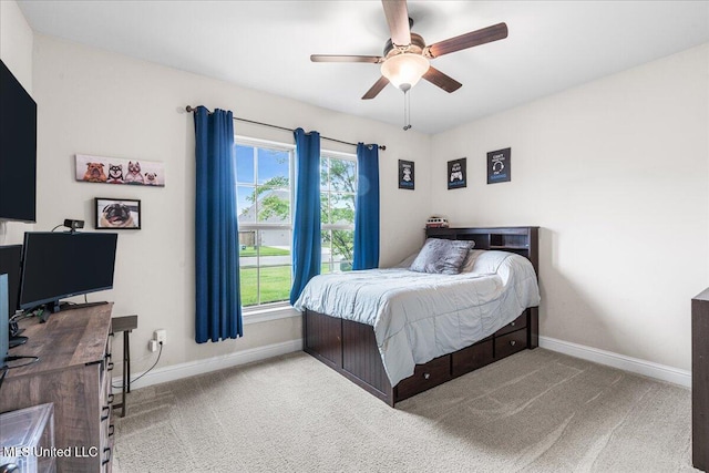 carpeted bedroom featuring baseboards and ceiling fan