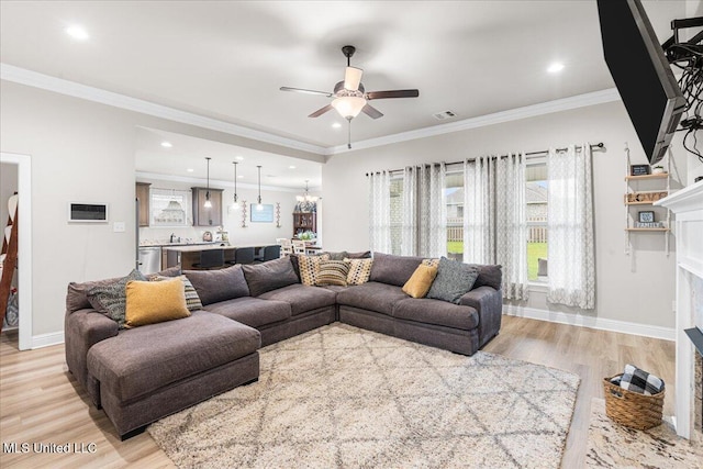 living room featuring ceiling fan, a fireplace with flush hearth, light wood-type flooring, recessed lighting, and ornamental molding