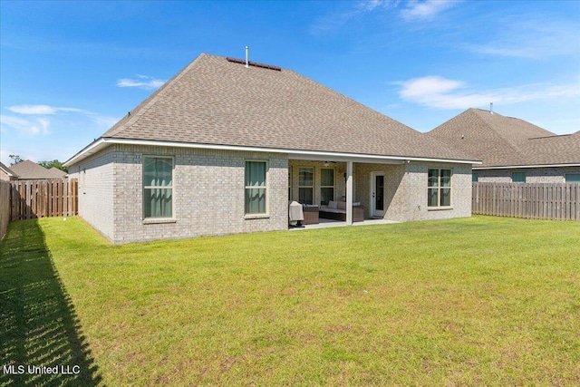 back of property with a patio area, roof with shingles, and brick siding