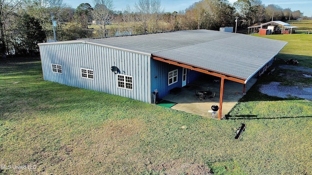 view of pole building with a carport and a lawn