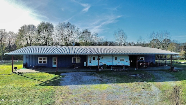 single story home with metal roof, a front lawn, a standing seam roof, and driveway