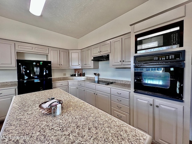 kitchen featuring gray cabinets, light countertops, a textured ceiling, under cabinet range hood, and black appliances