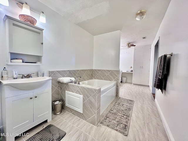 bathroom featuring visible vents, vanity, a textured ceiling, and a bath