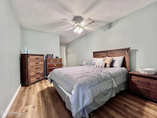 bedroom featuring a textured ceiling, ceiling fan, wood finished floors, and baseboards