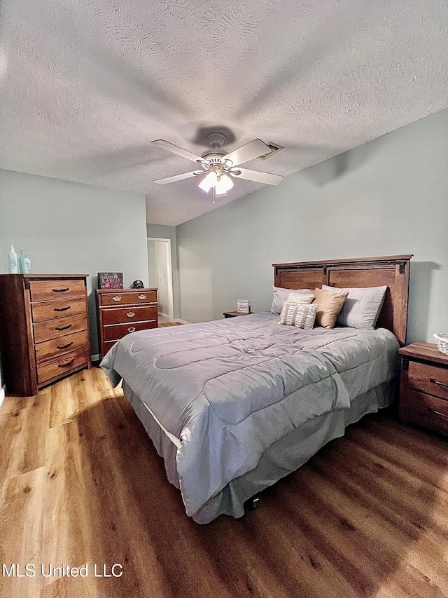 bedroom featuring ceiling fan, a textured ceiling, and wood finished floors