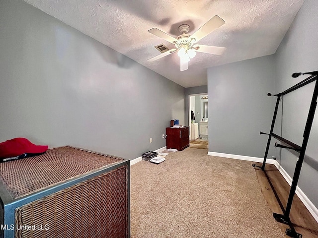 bedroom with a textured ceiling, carpet floors, visible vents, and baseboards