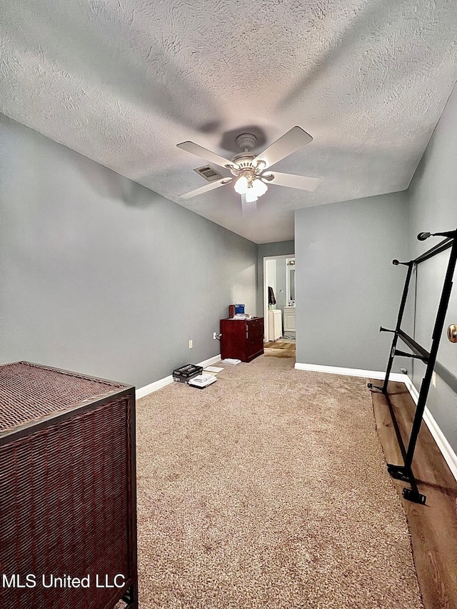 unfurnished bedroom with carpet, visible vents, ceiling fan, a textured ceiling, and baseboards