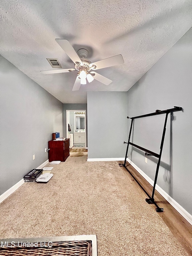 unfurnished bedroom featuring a ceiling fan, baseboards, visible vents, and a textured ceiling