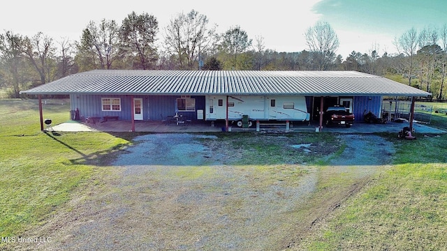 view of front facade featuring a front lawn, metal roof, and dirt driveway