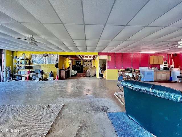 interior space featuring washer / dryer, a drop ceiling, unfinished concrete flooring, and ceiling fan