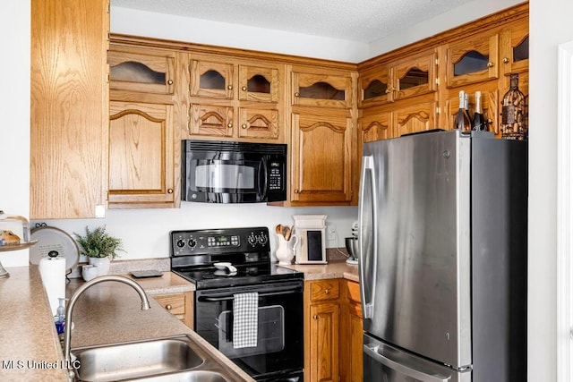 10840 Ala Moana St, Diamondhead, MS 39525 - kitchen featuring black appliances, light countertops, glass insert cabinets, and brown cabinetry