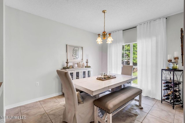 10840 Ala Moana St, Diamondhead, MS 39525 - dining room with a chandelier, a textured ceiling, light tile patterned floors, and baseboards