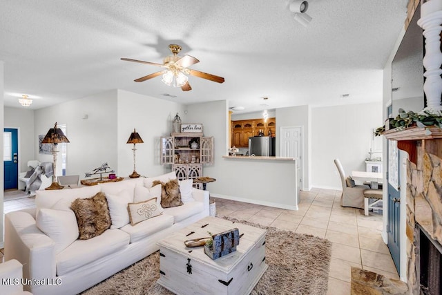 10840 Ala Moana St, Diamondhead, MS 39525 - living room with a ceiling fan, light tile patterned flooring, a textured ceiling, and a fireplace