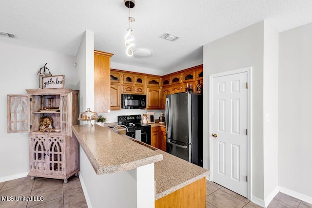 10840 Ala Moana St, Diamondhead, MS 39525 - kitchen with black appliances, light countertops, a peninsula, light tile patterned floors, and brown cabinets