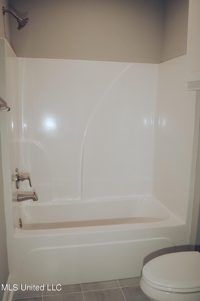 bathroom featuring toilet, bathing tub / shower combination, and tile patterned flooring