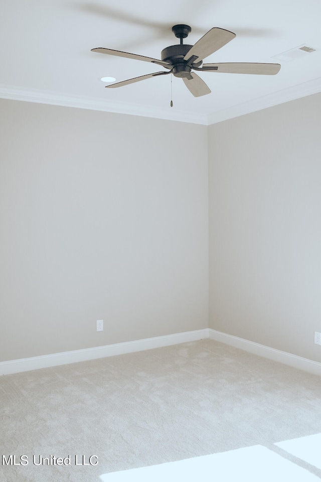 spare room with crown molding, carpet flooring, and ceiling fan