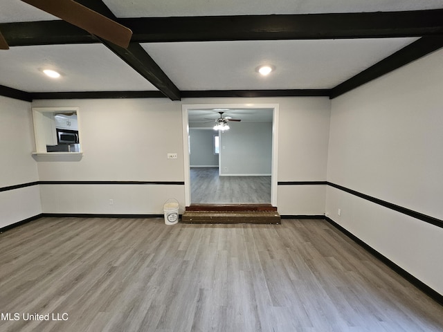spare room featuring a ceiling fan, baseboards, recessed lighting, wood finished floors, and beamed ceiling