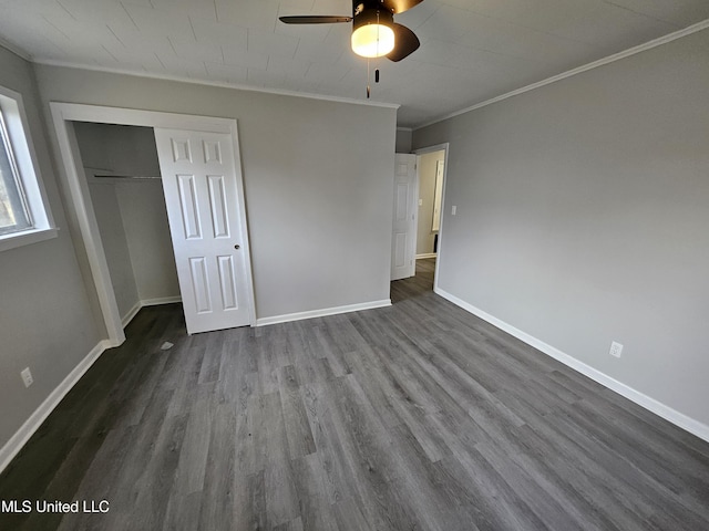 unfurnished bedroom with a closet, ornamental molding, baseboards, and dark wood-style floors