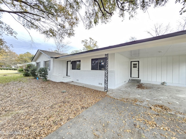 view of front facade featuring a carport, driveway, and brick siding