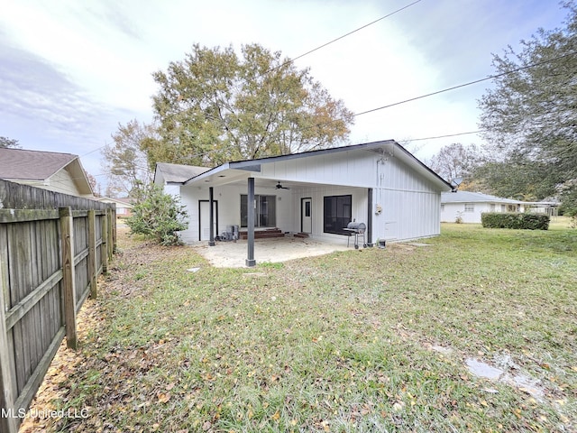 back of property featuring a lawn, a ceiling fan, a patio, and fence
