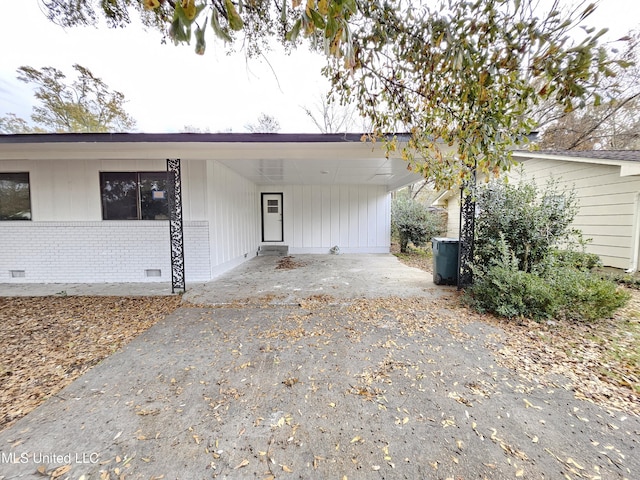 ranch-style home featuring crawl space, brick siding, driveway, and a carport