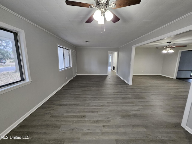 empty room featuring baseboards, ornamental molding, ceiling fan, and dark wood-type flooring