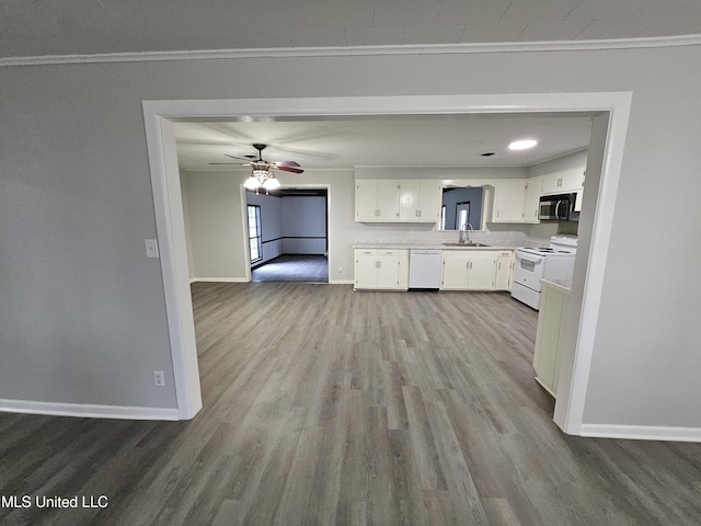 kitchen featuring crown molding, baseboards, and white appliances