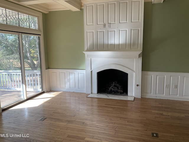 unfurnished living room featuring beamed ceiling and hardwood / wood-style floors