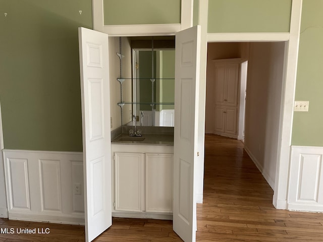 hallway featuring hardwood / wood-style floors and sink