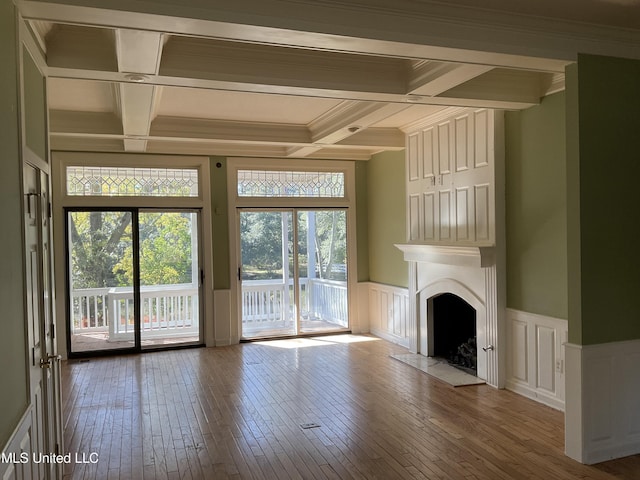 unfurnished living room featuring beamed ceiling, coffered ceiling, and hardwood / wood-style flooring