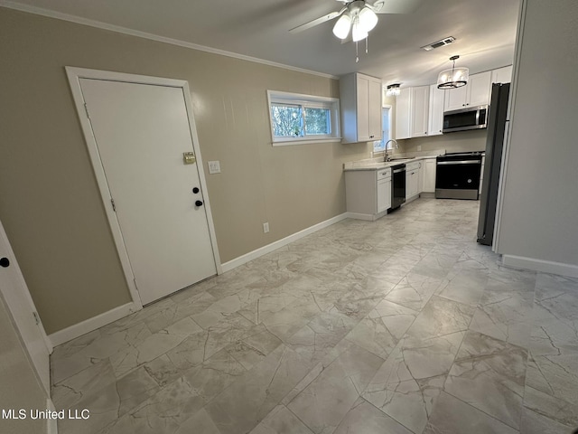 kitchen featuring pendant lighting, sink, crown molding, stainless steel appliances, and white cabinets