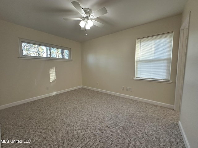 carpeted spare room featuring ceiling fan