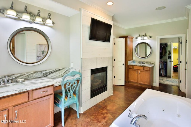 2948 Grove Meadows Dr, Nesbit, MS 38651 - bathroom featuring crown molding, a tub with jets, vanity, a fireplace, and a walk in closet