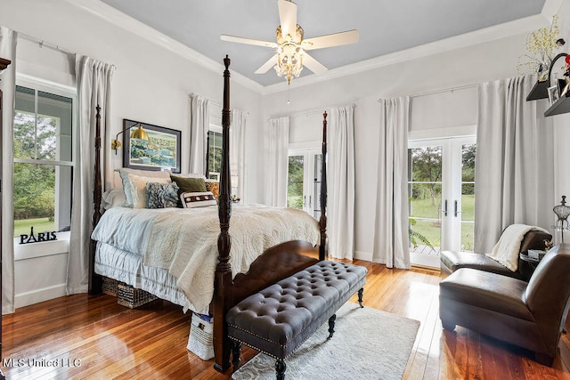 bedroom featuring ceiling fan, hardwood / wood-style flooring, access to outside, and multiple windows