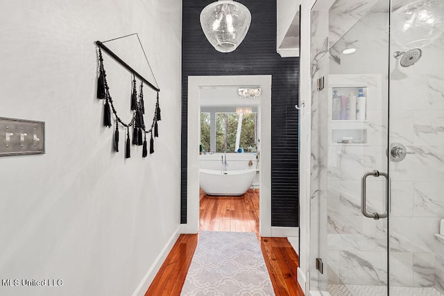 bathroom with separate shower and tub and hardwood / wood-style floors