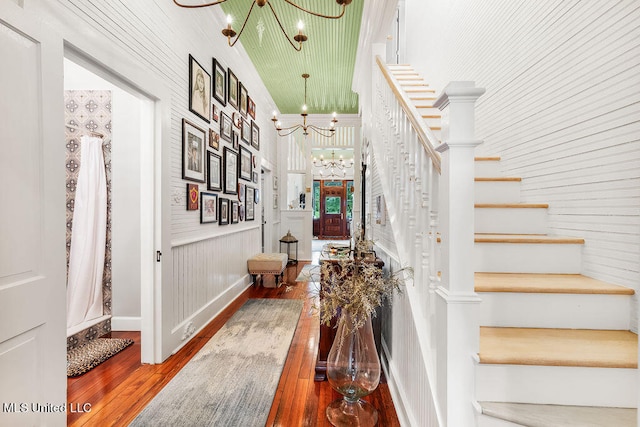 stairway with a notable chandelier and hardwood / wood-style flooring