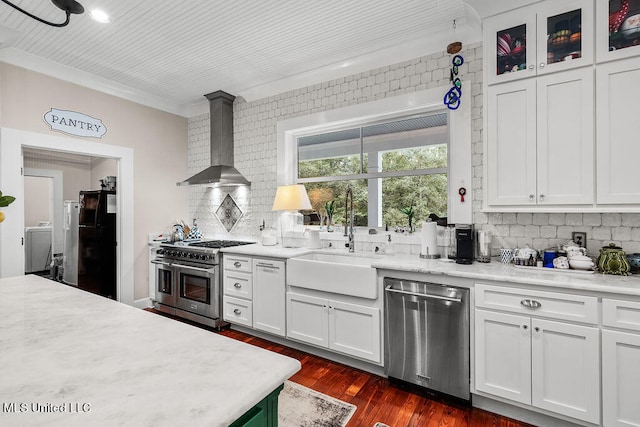 kitchen featuring wall chimney range hood, white cabinets, dark hardwood / wood-style floors, sink, and stainless steel appliances