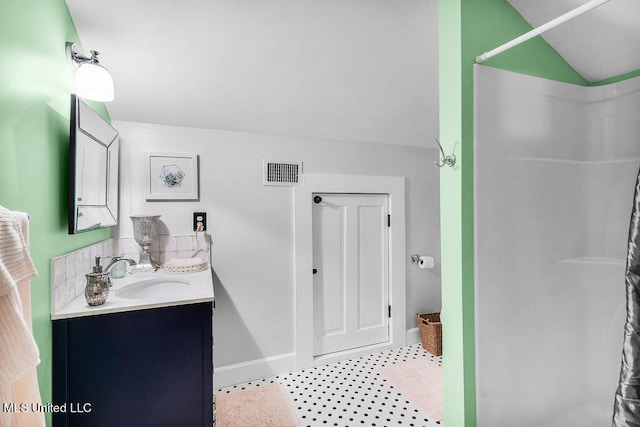 bathroom featuring vanity, vaulted ceiling, and curtained shower