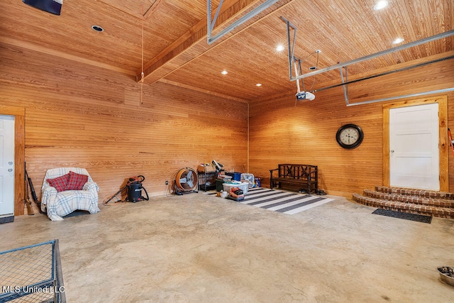 misc room with wood walls, concrete flooring, and wooden ceiling