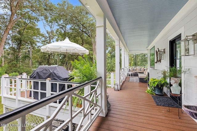 wooden terrace with an outdoor living space