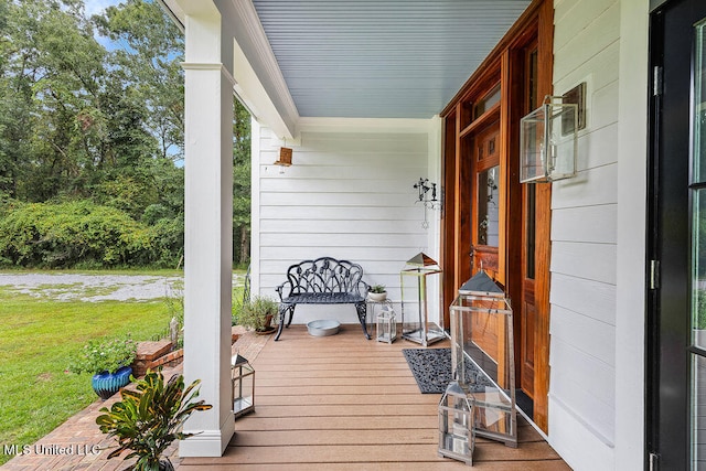 wooden terrace featuring a yard and a porch