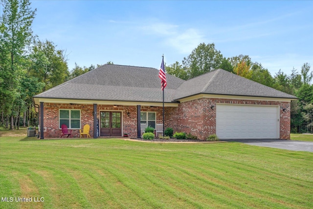 view of front of home featuring central air condition unit, a front yard, and a garage